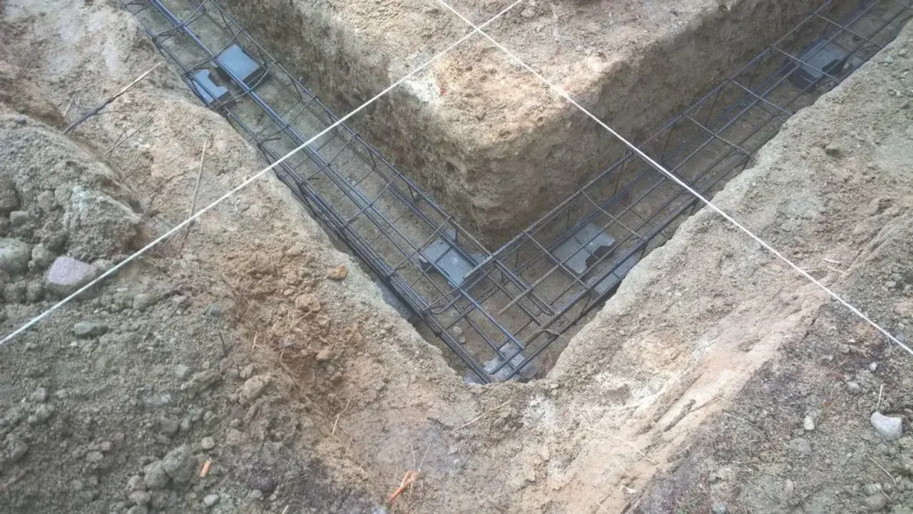 Gotowe zbrojenie fundamentu w wykopie. Stalowe pręty tworzą siatkę, która wzmocni beton.